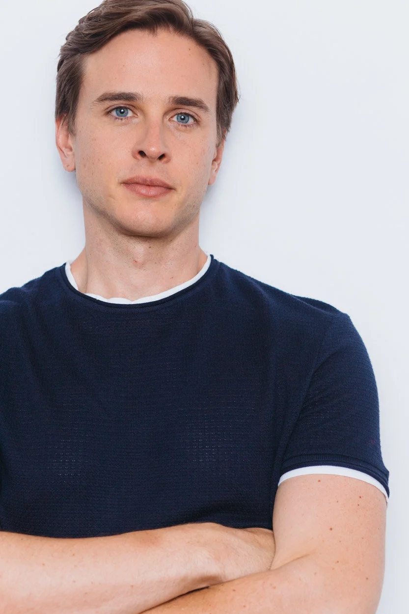 Grant Harling headshot, navy t-shirt, arms crossed